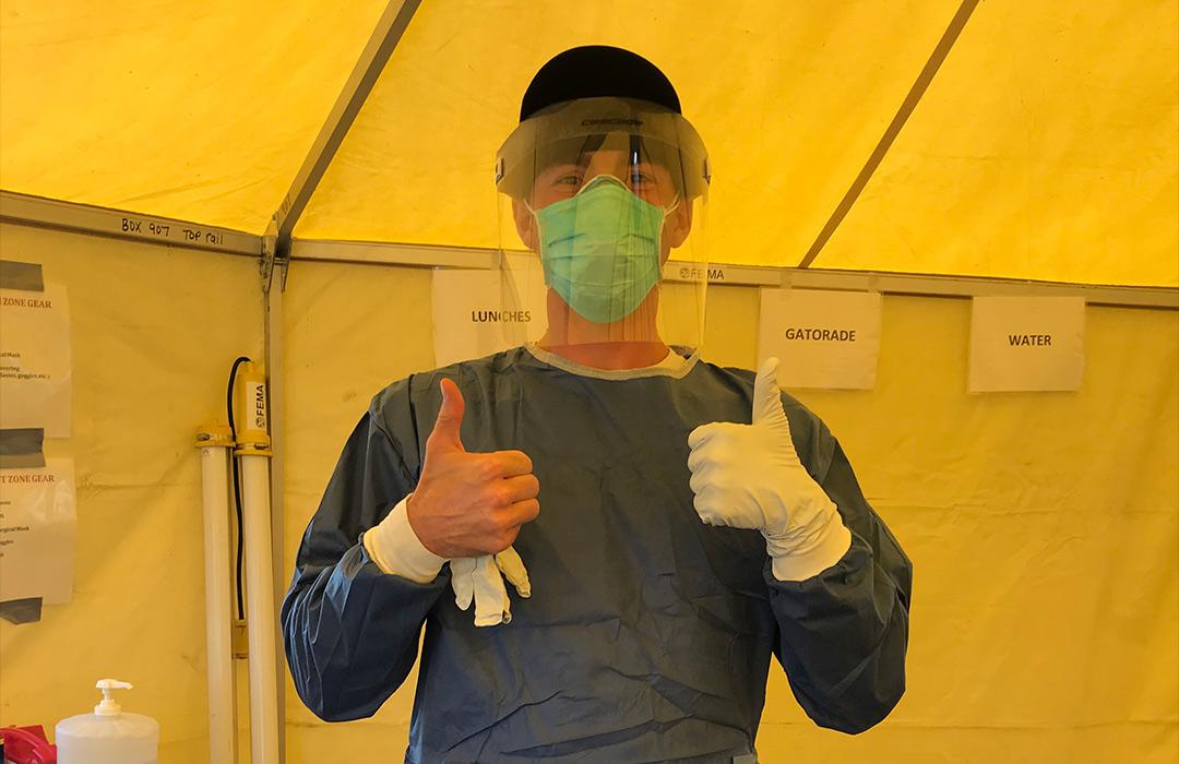 Bango giving the thumbs-up sign in full protective gear for COVID-19 testing