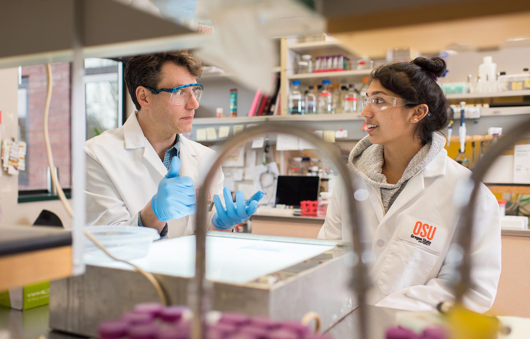 Professor, Ryan Mehl and student, Sonia Grutzius talking in the lab.