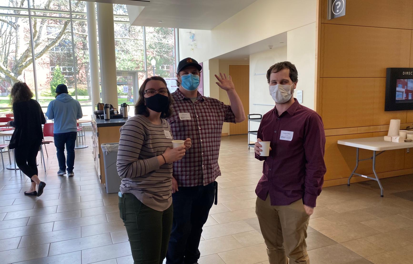 Three members of the Biophysical Society Student Chapter wave to the camera in Linus Pauling Science Center