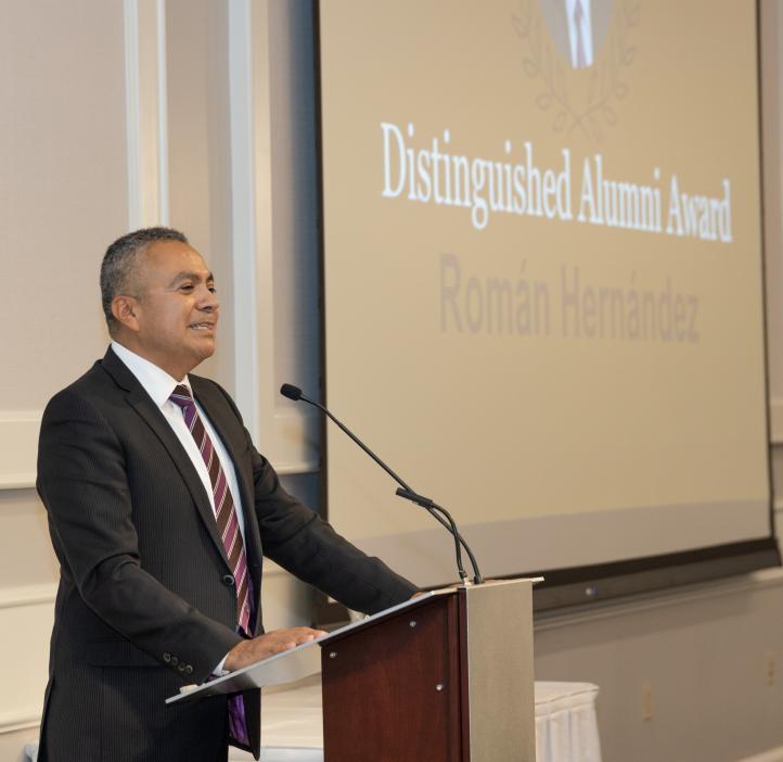 Roman Hernandez speaking at a podium