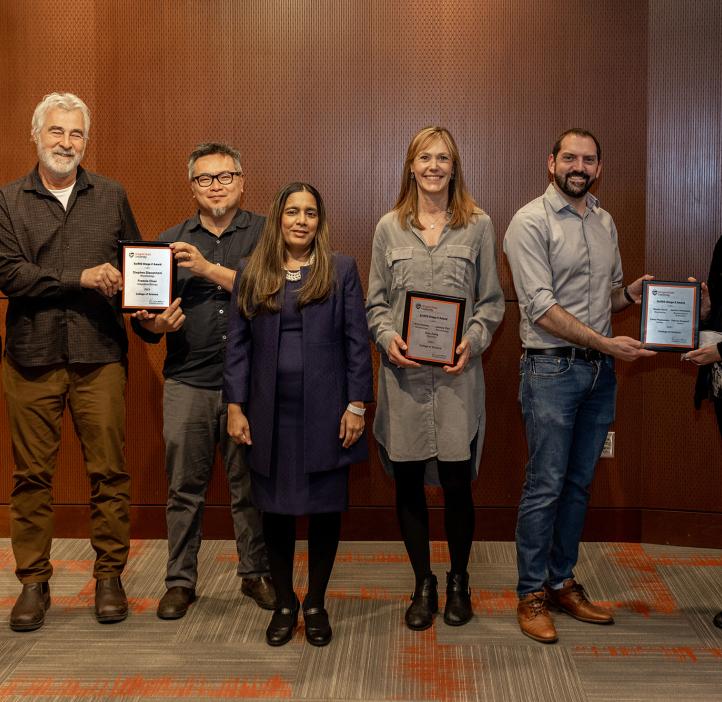 A number of faculty posing with awards.